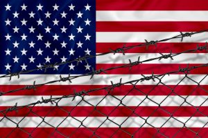 american flag with barbed wire across it